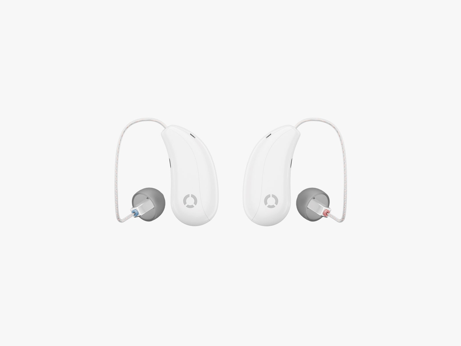 Two side by side white overtheear hearing aids with grey ear canal cushions