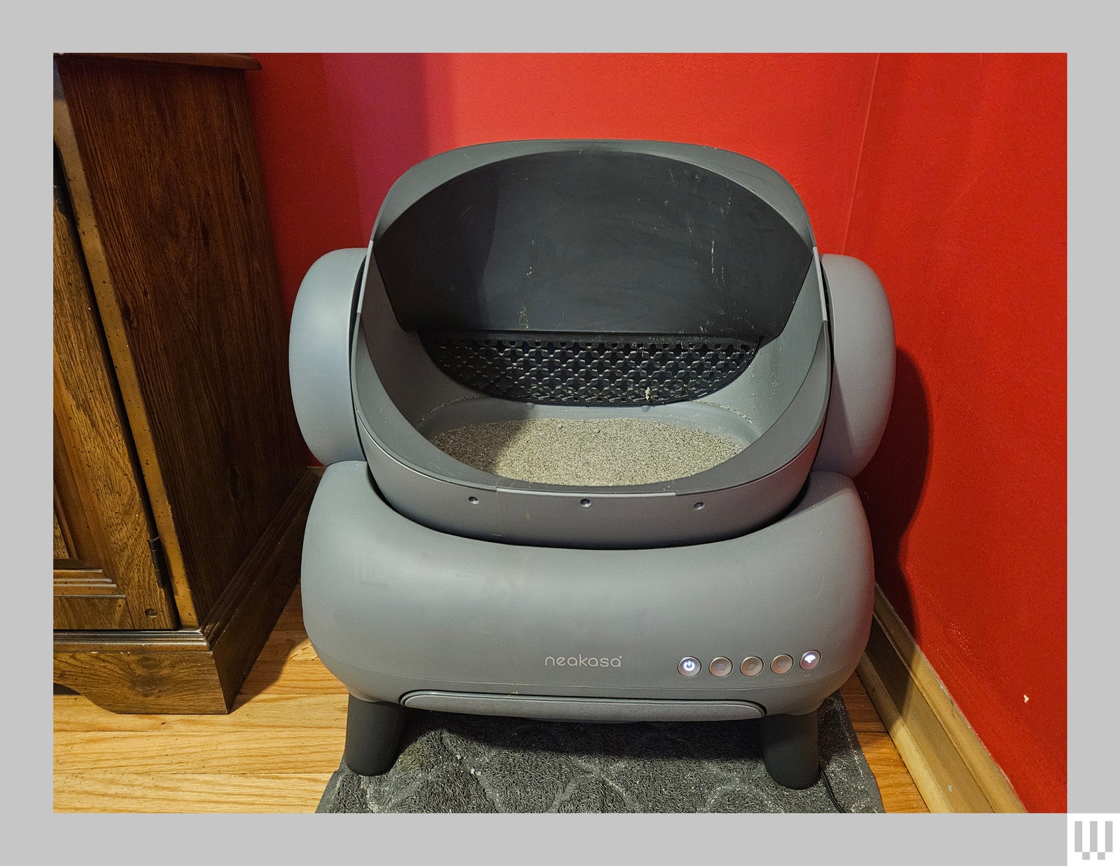 Front view of automatic cat litter box with large semiopen top and rounded rectangular base with 4 legs for support