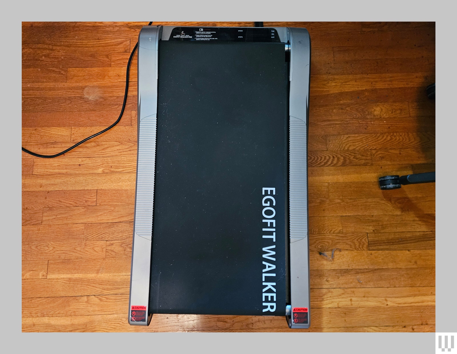 Overhead view of black treadmill with grey sides sitting on hardwood floor