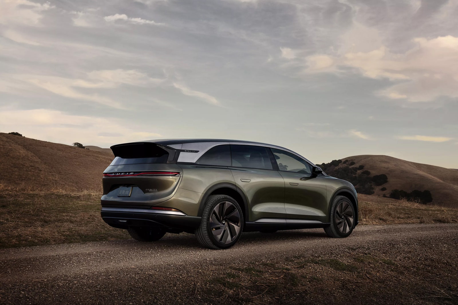 A sleek dark green SUV on a dirt road