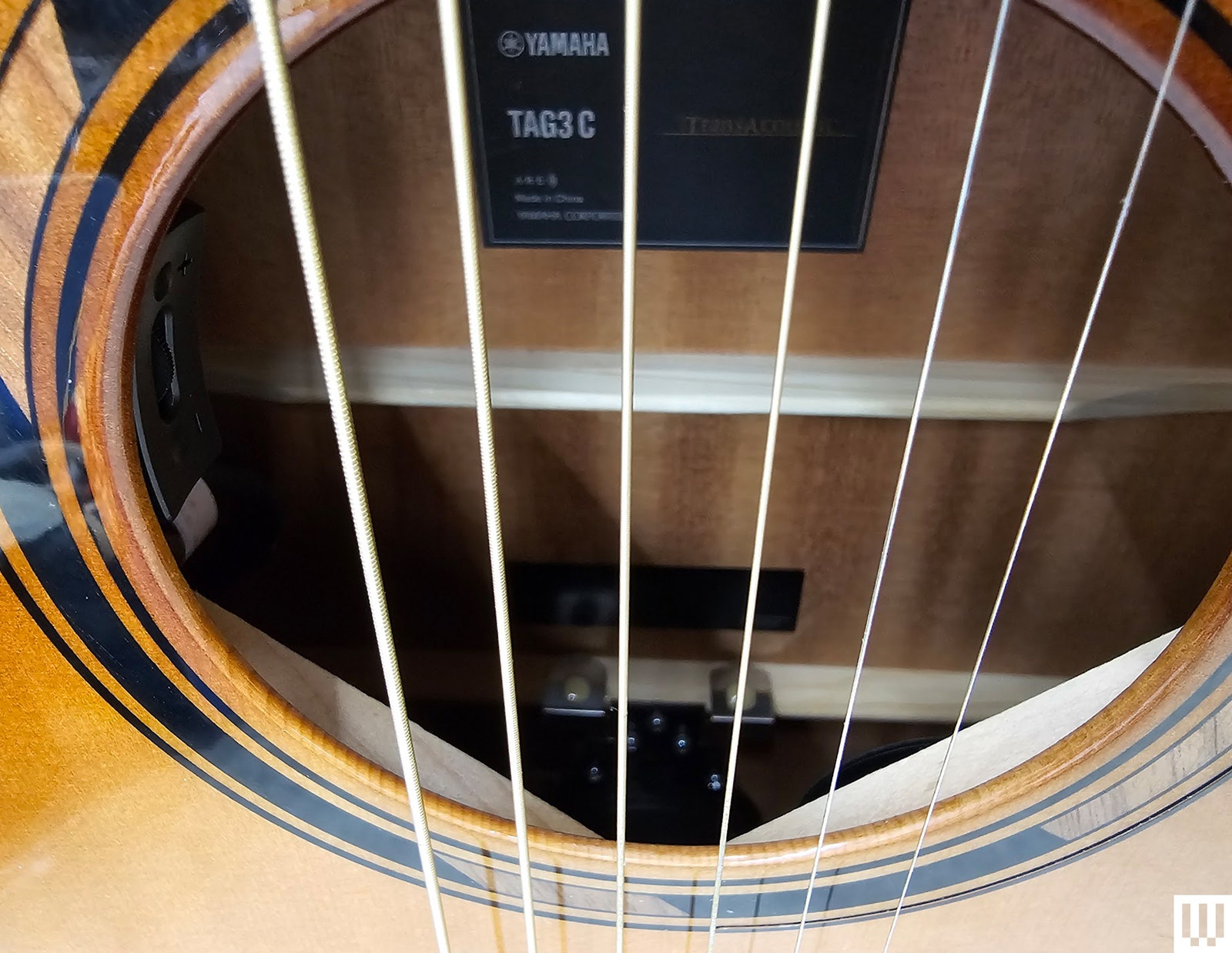 Closeup of Yamaha TAG3 C Acoustic Guitar showing the inside through the strings