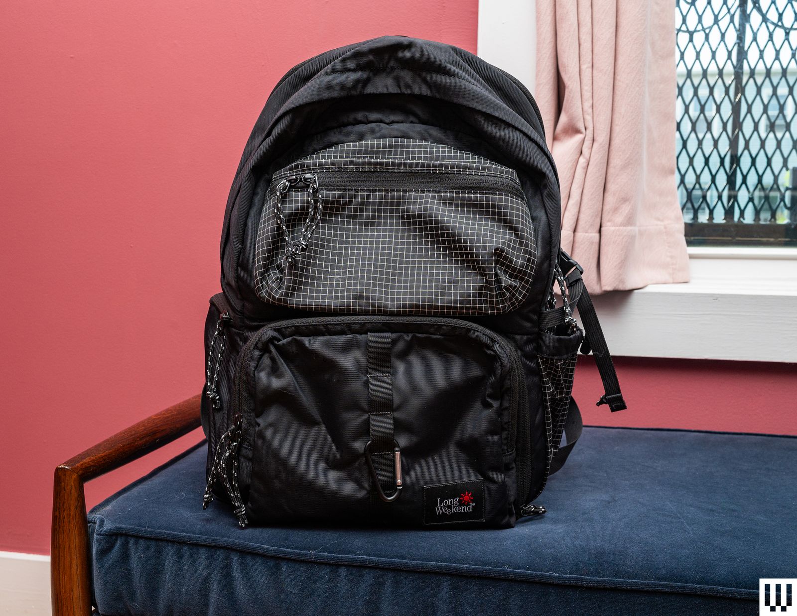 Front view of black camera backpack with multiple zippered pouches in the front