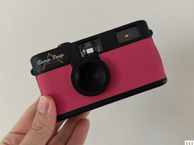 A hand holding up a pink Camp Snap Digital Camera