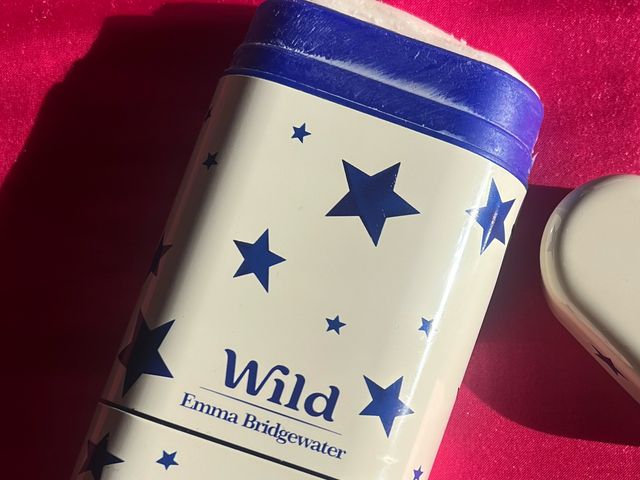 Wild Natural Deodorant, a white metallic case with blue decoration, on a raspberry-colored cloth