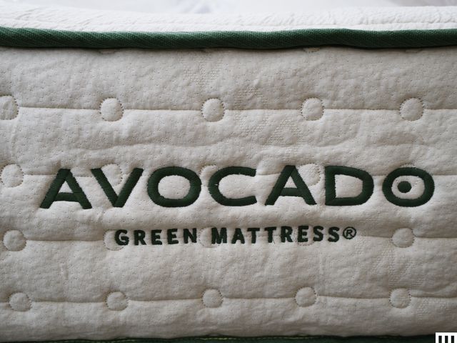 Closeup of an Avocado Green Mattress, showing the thick white side with green trim