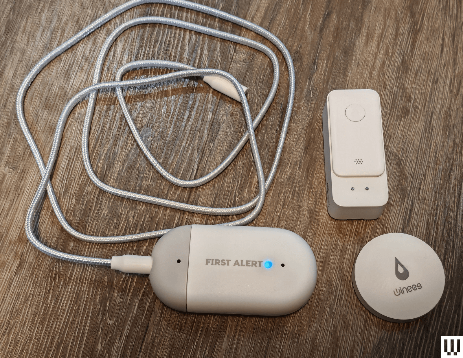 Three different water leak detecting devices in a variety of shapes one with a long cord