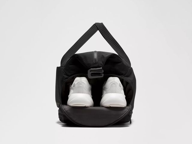 Black bag with handle and white sneakers sticking out