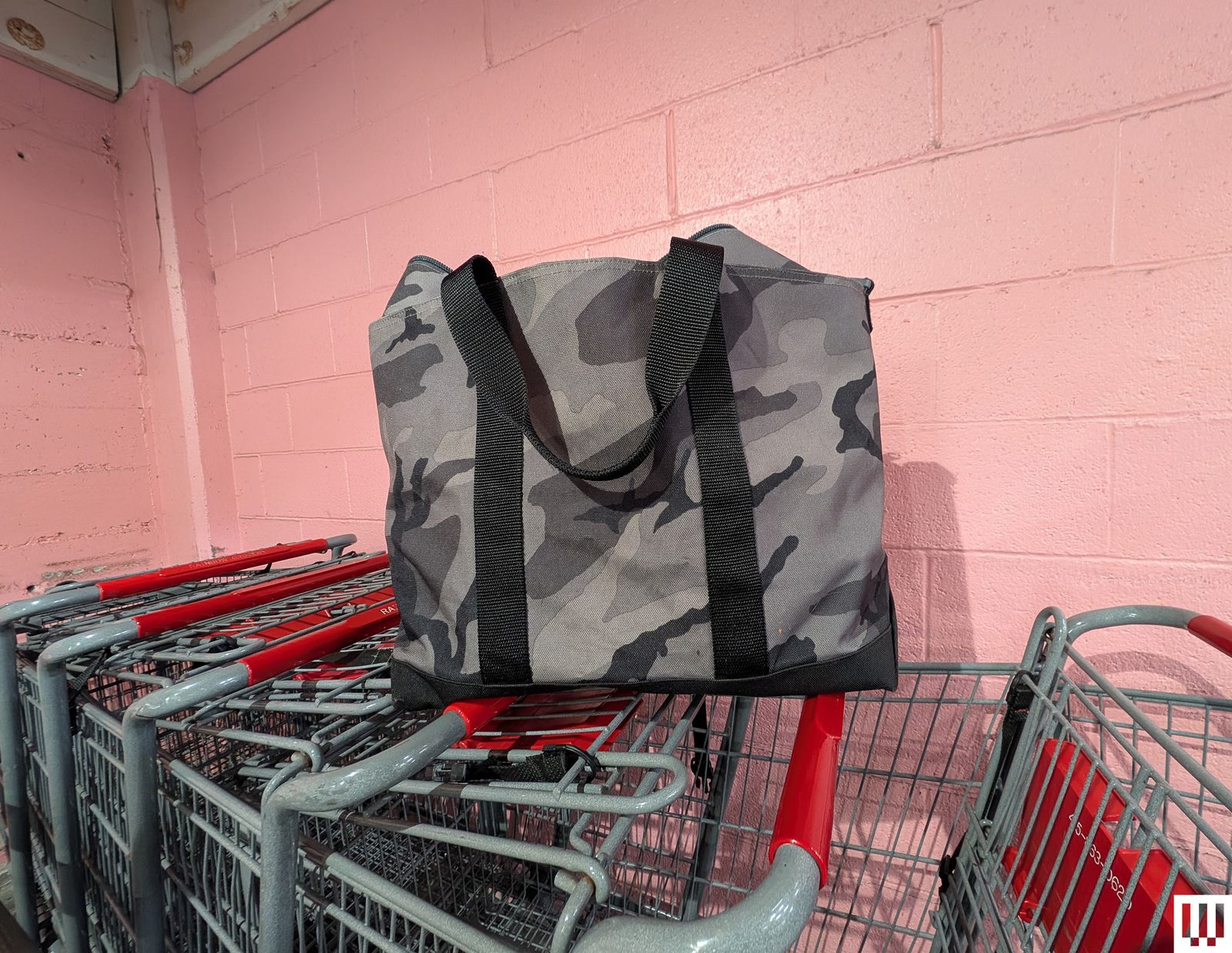 Large tote bag with black and grey camouflage pattern on top of shopping cards
