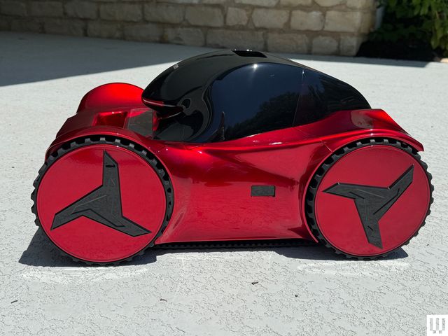 Red pool cleaner with black top and sleek racecar-like edges